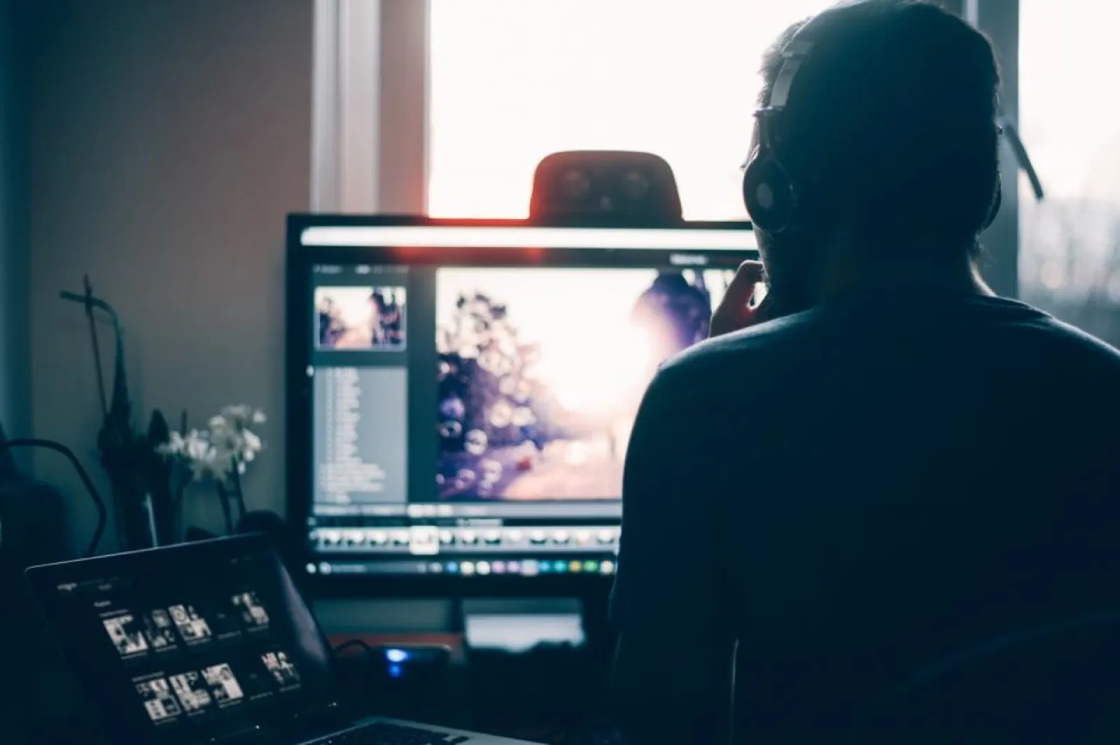 Editor wearing headphones working at a monitor