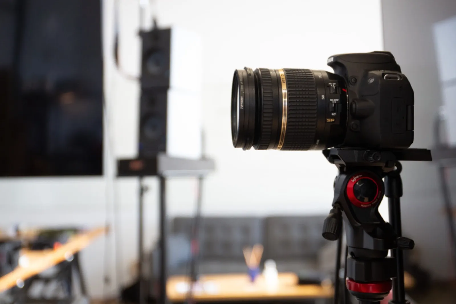 Camera on a tripod pointed at a desk in a small studio