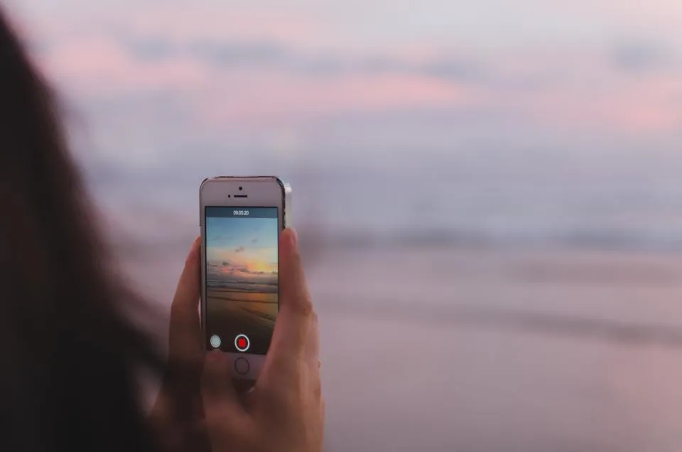 Person recording a video of the sea on a phone